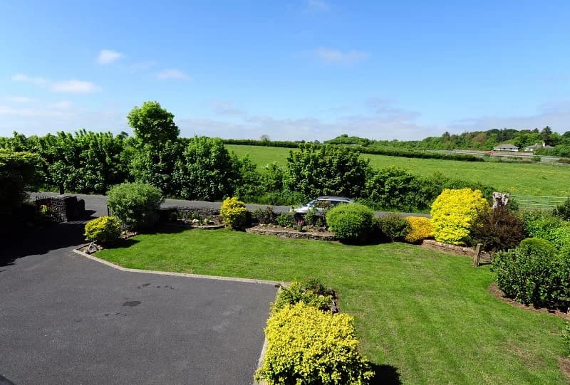 The lawn and planted borders behind the house, looking out over open fields