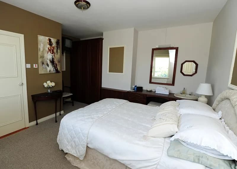 Room 1 seen from the door, with a dark wood wardrobe, dressing table and washbasin