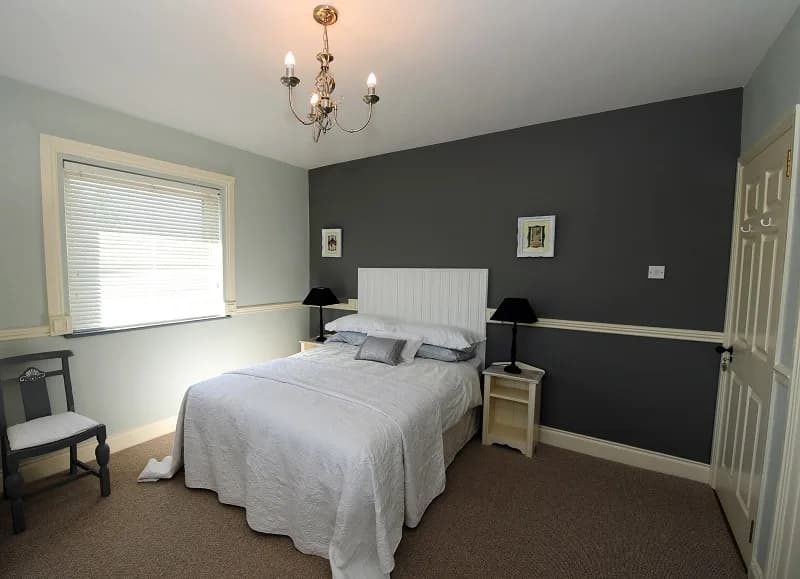 Room 3, a double room with a slate grey feature wall and a white panelled headboard